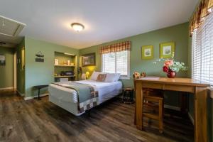 a bedroom with green walls and a bed and a desk at Elk Meadow Cabins 19B Johnny Redwood - Single Room in Orick