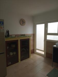 a kitchen with a cupboard and a clock on the wall at Casa Katze, 2 dormitorios, céntrica, playa y descanso in Carboneras
