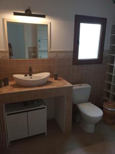 a bathroom with a sink and a toilet and a mirror at Casa Katze, 2 dormitorios, céntrica, playa y descanso in Carboneras
