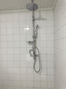 a shower in a white tiled bathroom at studio Corossol, 100 mètre de la plage, bas du fort, le Gosier, Guadeloupe in Le Gosier
