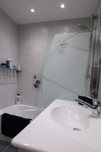 a white bathroom with a sink and a bath tub at Appartement centre ville Rixheim in Rixheim