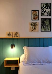 1 cama con cabecero verde y mesita de noche de madera junto a la cama en Casa dos Lírios en Alto Paraíso de Goiás