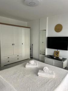- une chambre blanche avec 2 serviettes sur un lit dans l'établissement Studio entre plages et Monaco climatisé parking, à Roquebrune-Cap-Martin