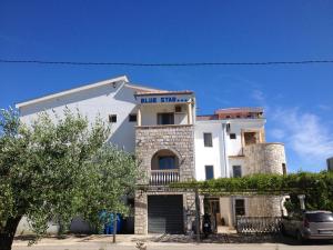 a white building with a blue finish sign on it at Blue Star Apartments in Ulcinj