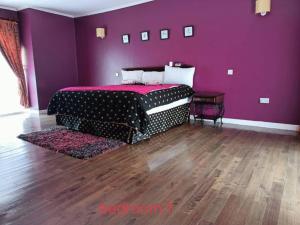 ナイロビにあるKaren white villaの紫色のベッドルーム(ベッド1台付)が備わります。