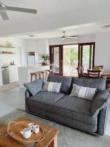 ein Wohnzimmer mit einem Sofa und einem Tisch in der Unterkunft Birdsong Haven, Lennox Head in Lennox Head