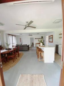 a living room with a ceiling fan and a table at Birdsong Haven, Lennox Head in Lennox Head
