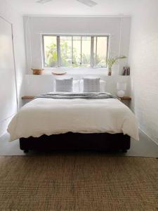 a bedroom with a large bed with a window at Birdsong Haven, Lennox Head in Lennox Head