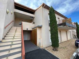 uma casa com uma escada que leva a uma garagem em App Le Golf T3 terrasse wifi pkg em Béziers