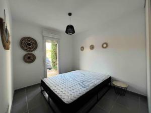 a bedroom with a bed in the corner of a room at App Le Golf T3 terrasse wifi pkg in Béziers