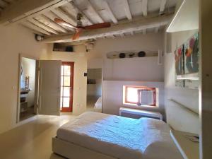sypialnia z dużym łóżkiem i oknem w obiekcie CASINA TOSCANA, Cozy studio in the heart of Campiglia Marittima with FREE Wi-Fi w mieście Campiglia Marittima