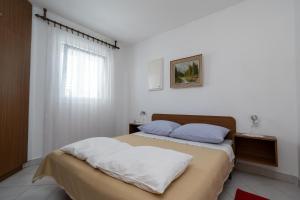 una camera con un letto con due cuscini di Apartments with a parking space Povljana, Pag - 227 a Povljana (Pogliana)