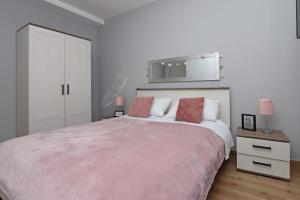 Un dormitorio blanco con una cama grande y un espejo. en Apartment Pag 6412b, en Pag