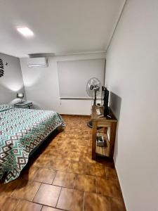 1 dormitorio con 1 cama y 1 mesa con ventilador en Departamento céntrico en Lujan de Cuyo en Luján de Cuyo