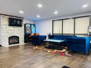 a living room with blue couches and a fireplace at Baymont by Wyndham La Crosse/Onalaska in Onalaska
