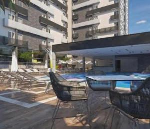 a patio with chairs and a table and a pool at SPAZZIO Andrian & Silva - INCLUSOS INGRESSOS DO PARQUE in Caldas Novas