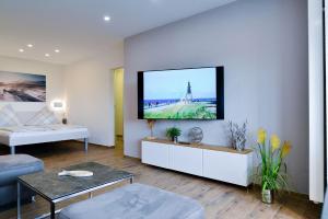 sala de estar con TV de pantalla plana en la pared en Strandhochhaus SB11, en Cuxhaven