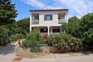 a white house with flowers in front of it at Apartments with parking space Potocnica, Pag - 6338 in Borovići
