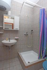 ein Bad mit einer Badewanne, einem Waschbecken und einer Dusche in der Unterkunft Apartments with a parking space Potocnica, Pag - 6338 in Borovići