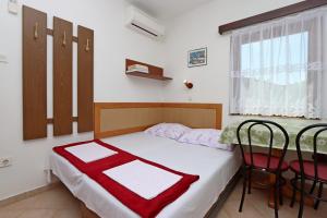 1 dormitorio con 1 cama con mesa y sillas en Apartments with a parking space Potocnica, Pag - 6338, en Borovići