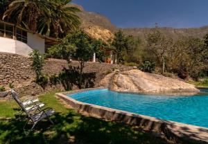 a swimming pool with a chair next to a house at Tropical Lodge in Cabanaconde
