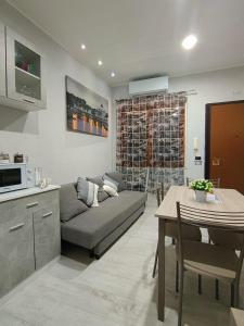 Roma Grey Suite في روما: مطبخ وغرفة معيشة مع أريكة وطاولة