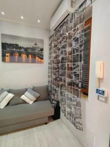a living room with a couch and a wall with photographs at Roma Grey Suite in Rome