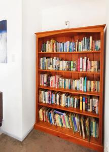 a book shelf filled with lots of books at 4 bdm house+sleep-out in Pukete.Close to The Base in Hamilton