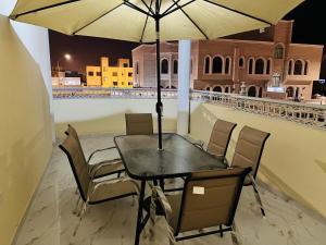 a table and chairs with an umbrella on a balcony at فيلا المزار villa almazar in Salalah