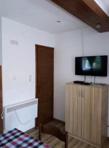 a room with a tv on top of a wooden cabinet at Petkovic Guesthouse in Žabljak