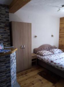 a bedroom with a bed and a cabinet in it at Petkovic Guesthouse in Žabljak