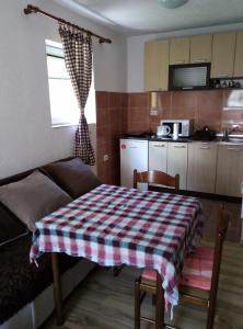 a room with a table and a couch and a kitchen at Petkovic Guesthouse in Žabljak