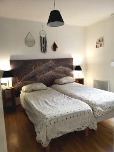 a bedroom with a large bed with a wooden headboard at Charmante petite maison in Soustons