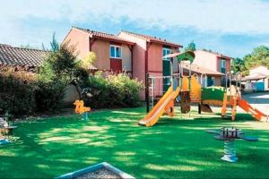 a yard with a playground with a slide at Charmante petite maison in Soustons
