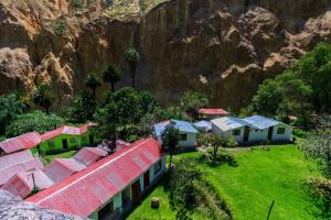 un groupe de maisons avec une montagne en arrière-plan dans l'établissement Tropical Lodge, à Cabanaconde