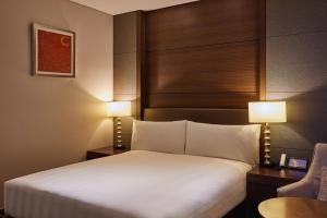 a hotel room with a bed and two lamps at LOTTE City Hotel Gimpo Airport in Seoul
