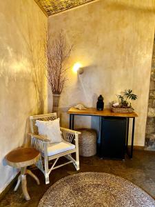 Cette chambre comprend un bureau, une chaise et une table. dans l'établissement Pousada Rancho das Dunas, à Santo Amaro