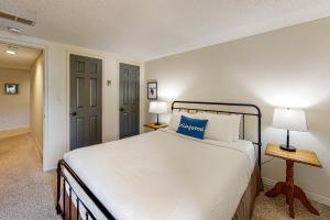 a bedroom with a large white bed and two lamps at Wintergreen 126 in Blue Mountains