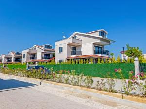 a large white house with flowers in front of it at Paradise Town Villa Lisa in Belek