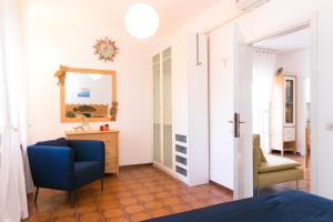 タラモーネにあるTalamone Apartmentのベッドルーム(青い椅子、鏡付)