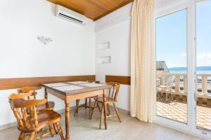 uma sala de jantar com mesa e cadeiras e uma varanda em Apartments by the sea Brela, Makarska - 18356 em Brela