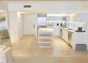 una cocina con armarios blancos y una escalera. en 1 Hotel & Homes Miami Beach Oceanfront Residence Suites By Joe Semary, en Miami Beach