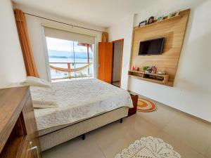 a bedroom with a bed and a large window at Casa Beira Mar Angra in Angra dos Reis