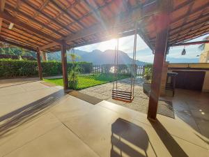a porch with a swing and a view of a mountain at Casa Beira Mar Angra in Angra dos Reis