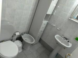 a white bathroom with a toilet and a sink at Depto Plaza España in Córdoba