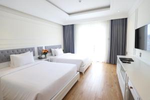 a hotel room with two beds and a television at Nature Hotel - Pham Hong Thai in Da Lat +65 photos