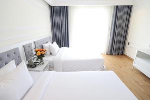 Postel nebo postele na pokoji v ubytování Le Marais Hotel Dalat