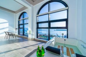 een grote kamer met een bad en ramen bij Goonghang Resort in Buan