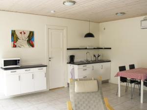 Eine Küche mit weißen Schränken und einem Tisch mit Tischdecke in der Unterkunft Juhl's Bed & Breakfast in Kolding