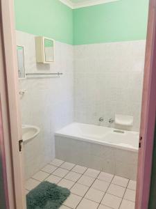 Devine Stay- Margate في مارغيت: حمام أبيض مع حوض ومغسلة
